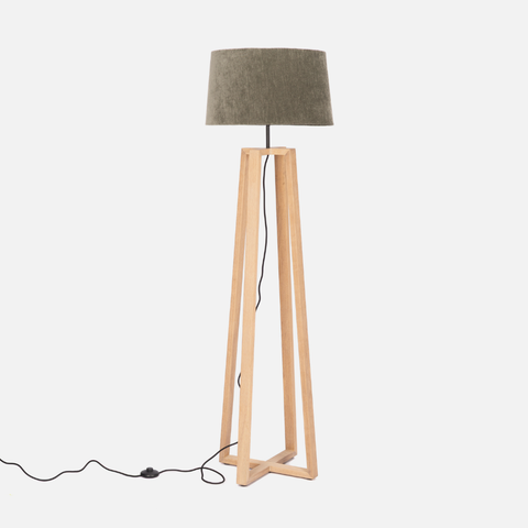 Floor lamp with wooden base and green fabric shade on a white background
