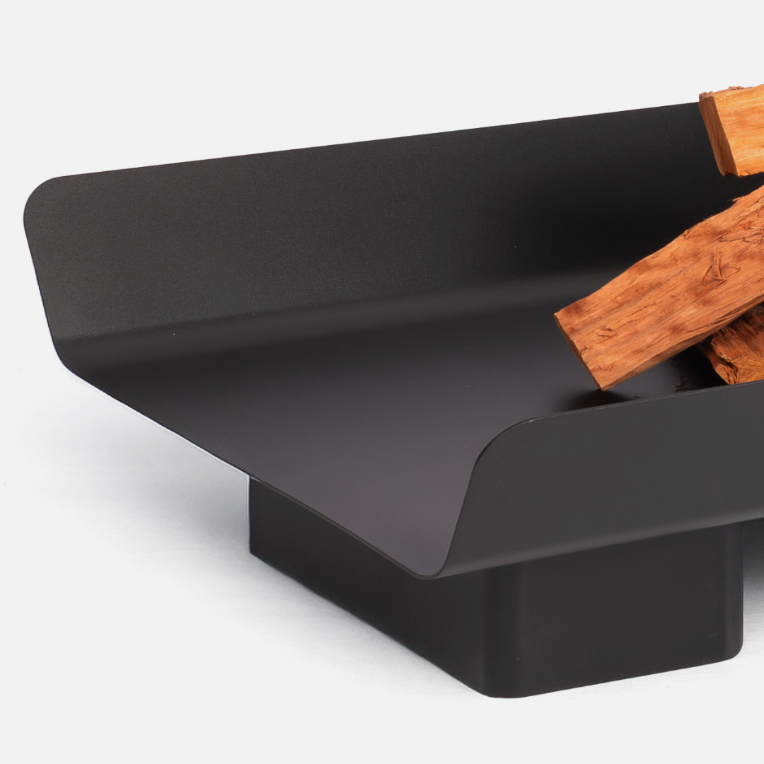 Black metal fire pit with wooden logs on a white background