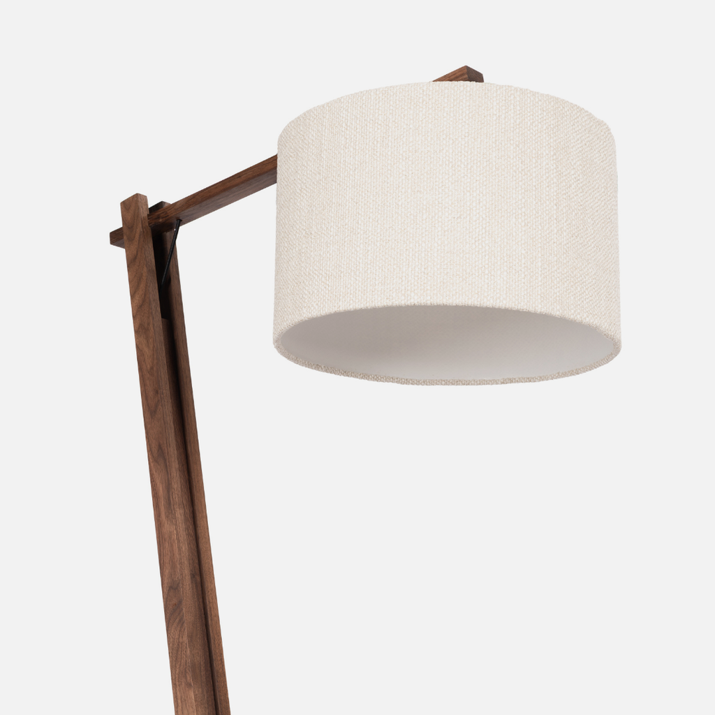 Floor lamp with a wooden base and white shade on a light gray background